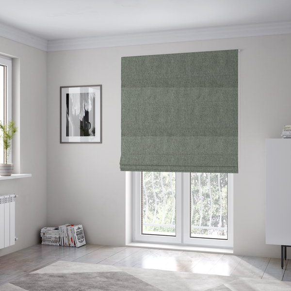 The fabric used to create these Roman blinds is a sage green upholstery fabric with a dense, diagonal textured weave.