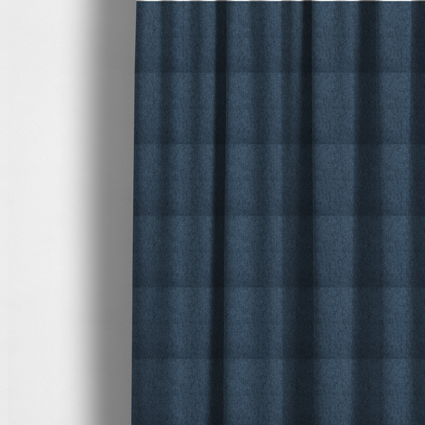 The fabric used to create these made-to-measure curtains is a navy blue upholstery fabric with a dense, diagonal textured weave.