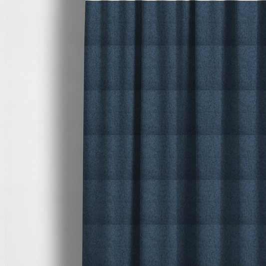 The fabric used to create these made-to-measure curtains is a navy blue upholstery fabric with a dense, diagonal textured weave.