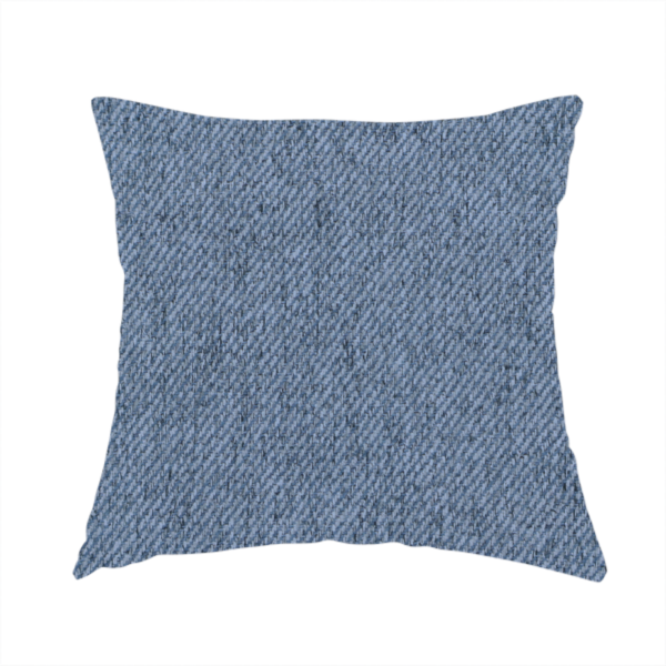 The fabric used to create this handmade cushion is a mid-blue upholstery fabric with a dense, diagonal textured weave.