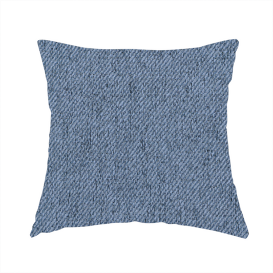 The fabric used to create this handmade cushion is a mid-blue upholstery fabric with a dense, diagonal textured weave.