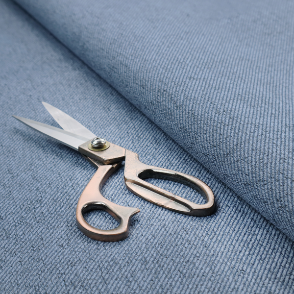 A mid-blue upholstery fabric with a dense, diagonal textured weave.