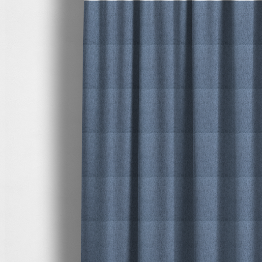 The fabric used to create these made-to-measure curtains is a mid-blue upholstery fabric with a dense, diagonal textured weave.