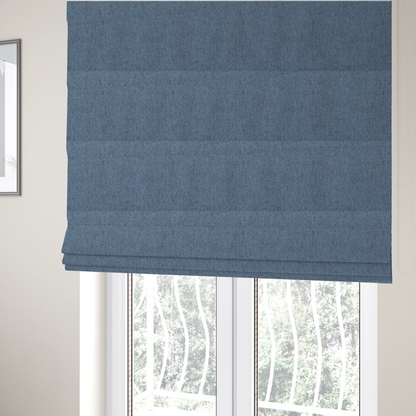 The fabric used to create these Roman blinds is a mid-blue upholstery fabric with a dense, diagonal textured weave.