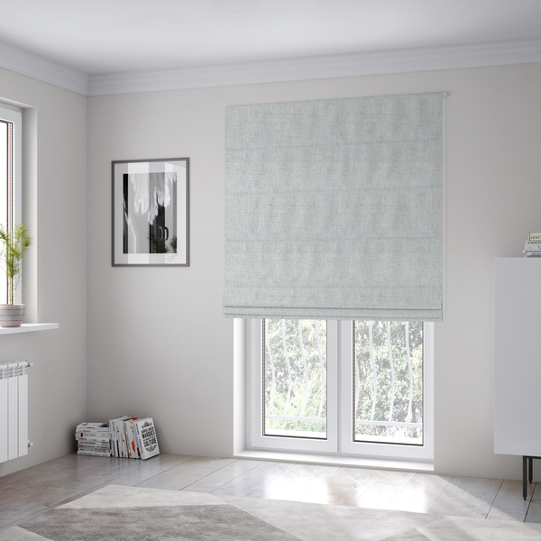 The fabric used to create these Roman blinds is a light grey upholstery fabric with a fine, dense textured weave.