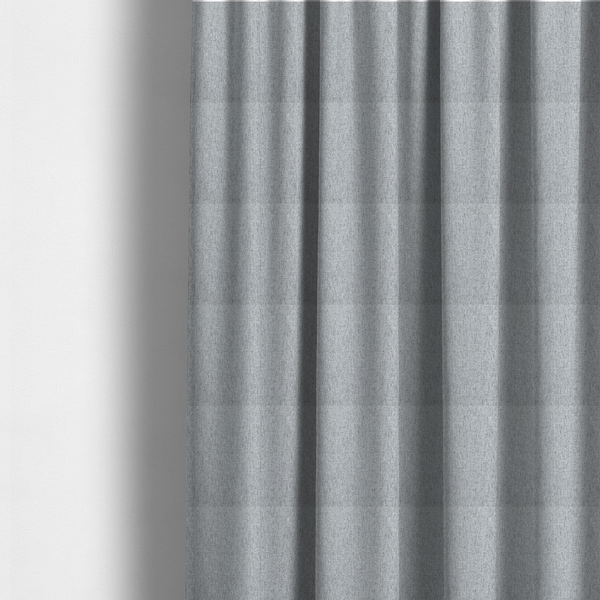 The fabric used to create these made-to-measure curtains is a light grey upholstery fabric with a dense, speckled textured weave.