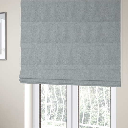 The fabric used to create these Roman blinds is a light grey upholstery fabric with a dense, speckled textured weave.