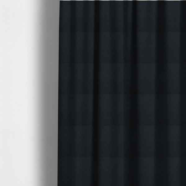 The fabric used to create these made-to-measure curtains is a midnight black upholstery fabric with a dense, diagonal twill weave.