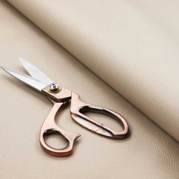 Boston Faux Leather Upholstery Fabric in a warm beige tone, showcasing a fine, textured leather grain.