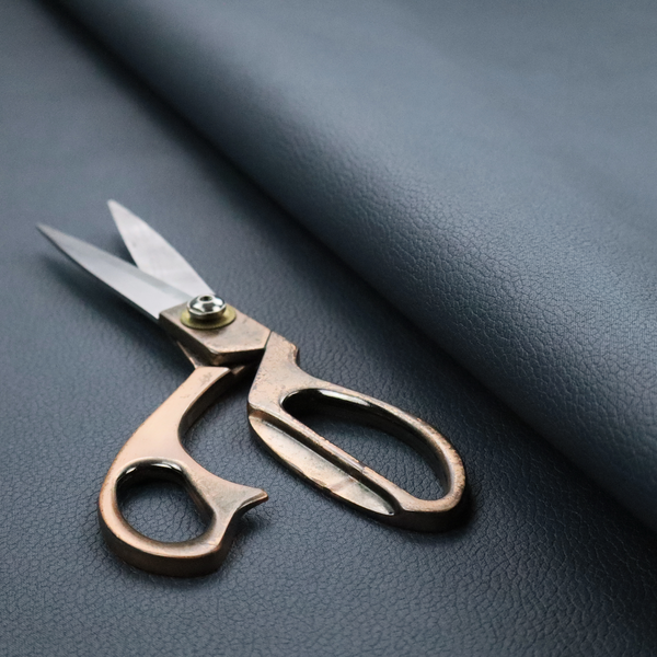 Boston Faux Leather Upholstery Fabric in a deep steel blue colour, highlighting a fine pebbled grain texture.