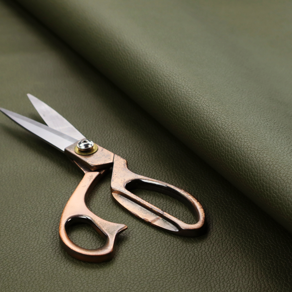 Boston Faux Leather Upholstery Fabric in a rich olive green colour, showcasing a fine pebbled grain texture.