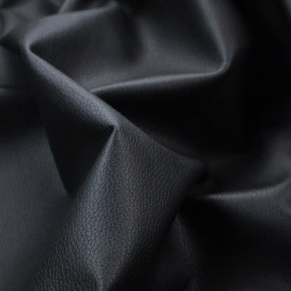 Boston Faux Leather Upholstery Fabric in a deep black colour, showcasing a fine pebbled grain texture.