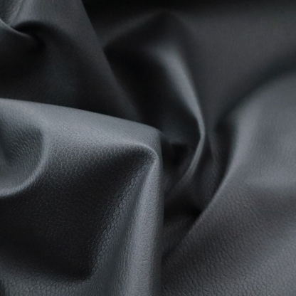 Boston Faux Leather Upholstery Fabric in a deep charcoal grey colour, showcasing a fine pebbled grain texture.