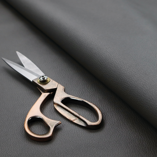 Boston Faux Leather Upholstery Fabric in a mid grey colour, showcasing a fine pebbled grain texture.
