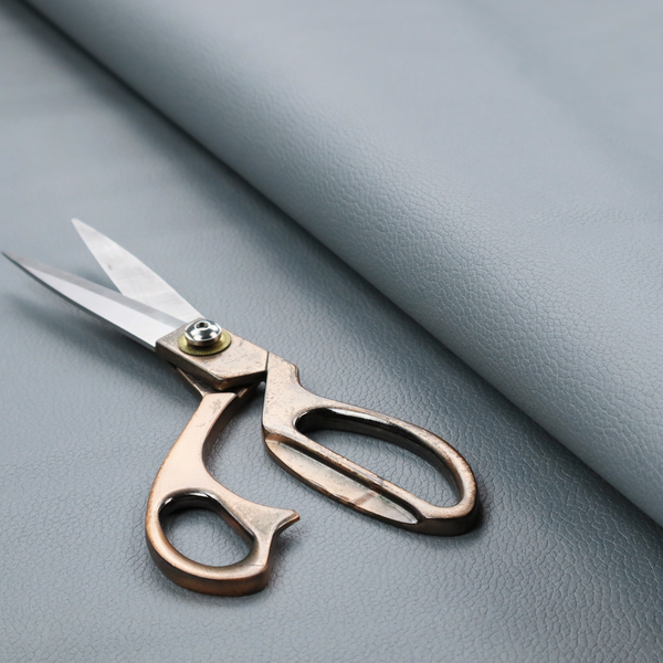 Boston Faux Leather Upholstery Fabric in a light grey colour, showcasing a fine pebbled grain texture.