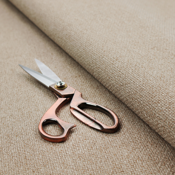 A beige or light taupe fabric featuring a distinct, tightly woven grid texture. The material showcases a multi-tonal, basket-weave style pattern with blending neutral threads, creating a warm, organic, and matte finish across the entire surface.