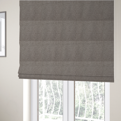 The fabric used to create these Roman blinds is a taupe or light greyish-brown fabric featuring a distinct, tightly woven grid texture. The material showcases a multi-tonal, basket-weave style pattern with blending neutral threads, creating a soft, heathered, and matte finish across the entire surface.