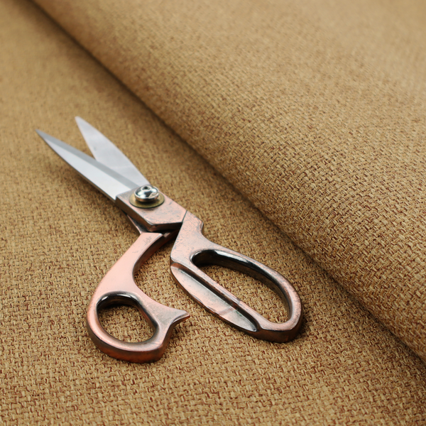 A golden brown or mustard fabric featuring a distinct, tightly woven grid texture. The material showcases a multi-tonal, basket-weave style pattern with blended ochre and tan threads, creating a warm, vibrant, and matte finish across the entire surface.