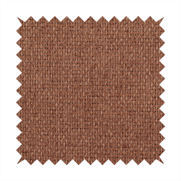 A rust or terracotta-brown fabric featuring a distinct, tightly woven grid texture. The material showcases a multi-tonal, basket-weave style pattern with interlaced copper and warm brown threads, creating a rich, earthy, and matte finish across the entire surface.