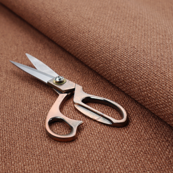 A rust or terracotta-brown fabric featuring a distinct, tightly woven grid texture. The material showcases a multi-tonal, basket-weave style pattern with interlaced copper and warm brown threads, creating a rich, earthy, and matte finish across the entire surface.