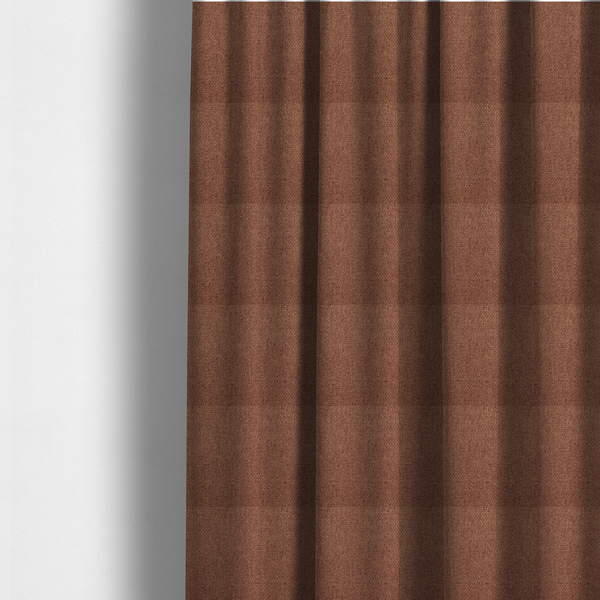 The fabric used to create these made-to-measure curtains is a rust or terracotta-brown fabric featuring a distinct, tightly woven grid texture. The material showcases a multi-tonal, basket-weave style pattern with interlaced copper and warm brown threads, creating a rich, earthy, and matte finish across the entire surface.