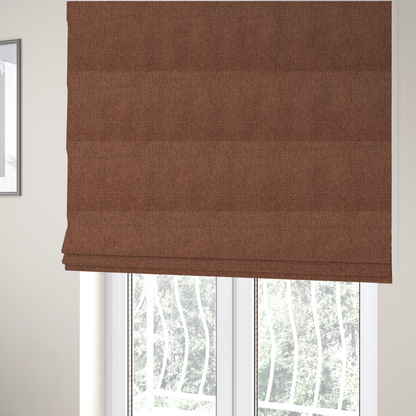The fabric used to create these Roman blinds is a rust or terracotta-brown fabric featuring a distinct, tightly woven grid texture. The material showcases a multi-tonal, basket-weave style pattern with interlaced copper and warm brown threads, creating a rich, earthy, and matte finish across the entire surface.