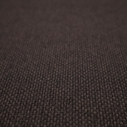 A dark chocolate or espresso brown fabric featuring a distinct, tightly woven grid texture. The material showcases a deep, multi-tonal, basket-weave style pattern with interlaced charcoal and dark brown threads, creating a rich, moody, and matte finish across the entire surface.