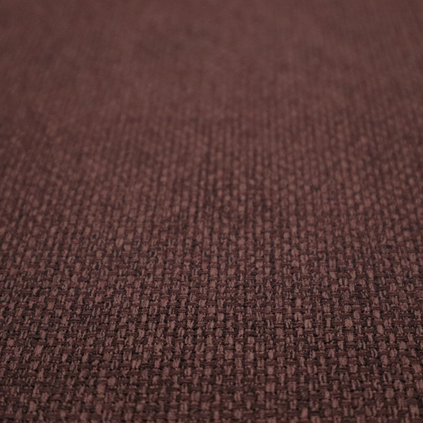 A deep maroon or burgundy fabric featuring a distinct, tightly woven grid texture. The material showcases a rich, multi-tonal, basket-weave style pattern with interlaced plum and dark earthy threads, creating a warm, elegant, and matte finish across the entire surface.