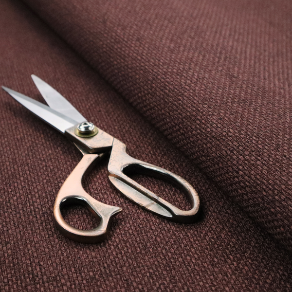 A deep maroon or burgundy fabric featuring a distinct, tightly woven grid texture. The material showcases a rich, multi-tonal, basket-weave style pattern with interlaced plum and dark earthy threads, creating a warm, elegant, and matte finish across the entire surface.