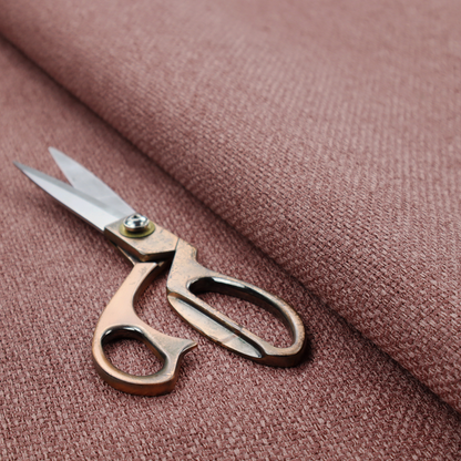 A dusty rose or mauve fabric featuring a distinct, tightly woven grid texture. The material showcases a multi-tonal, basket-weave style pattern with blended pinkish-brown and muted rose threads, creating a soft, sophisticated, and matte finish across the entire surface.