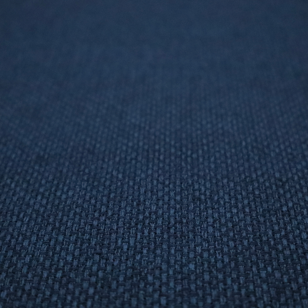 A deep navy or indigo blue fabric featuring a distinct, tightly woven grid texture. The material showcases a multi-tonal, basket-weave style pattern with blended dark blue and subtle charcoal threads, creating a rich, classic, and matte finish across the entire surface.