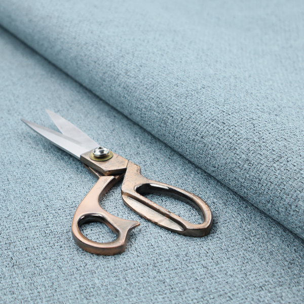 A light ice blue or pastel blue fabric featuring a distinct, tightly woven grid texture. The material showcases a multi-tonal, basket-weave style pattern with blended sky blue and subtle grey threads, creating a fresh, serene, and matte finish across the entire surface.