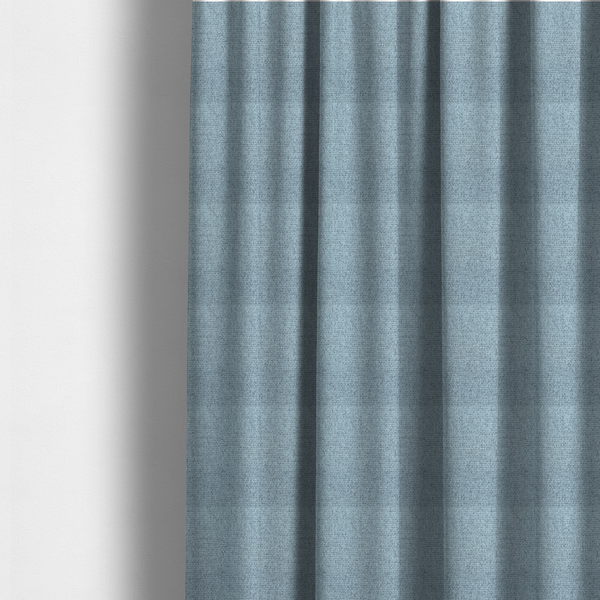 The fabric used to create these made-to-measure curtains is a light ice blue or pastel blue fabric featuring a distinct, tightly woven grid texture. The material showcases a multi-tonal, basket-weave style pattern with blended sky blue and subtle grey threads, creating a fresh, serene, and matte finish across the entire surface.