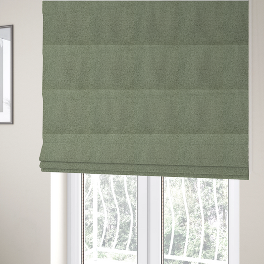 The fabric used to create these Roman blinds is a light sage or mint green fabric featuring a distinct, tightly woven grid texture. The material showcases a multi-tonal, basket-weave style pattern with blended pale green and subtle grey threads, creating a fresh, calming, and matte finish across the entire surface.