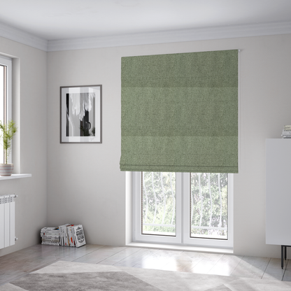 The fabric used to create these Roman blinds is a light sage or mint green fabric featuring a distinct, tightly woven grid texture. The material showcases a multi-tonal, basket-weave style pattern with blended pale green and subtle grey threads, creating a fresh, calming, and matte finish across the entire surface.
