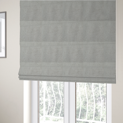 The fabric used to create these Roman blinds is a light silver-grey or ash-grey fabric featuring a distinct, tightly woven grid texture. The material showcases a multi-tonal, basket-weave style pattern with blended cool grey and subtle pale threads, creating a clean, neutral, and matte finish across the entire surface.