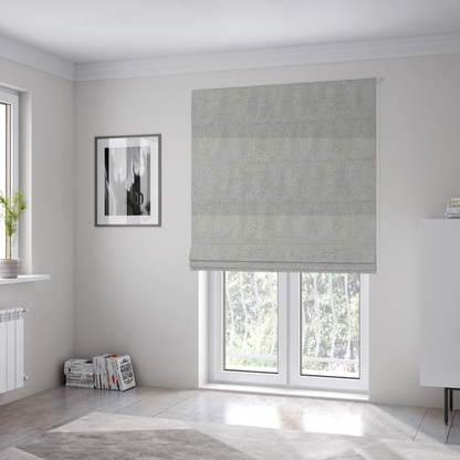 The fabric used to create these Roman blinds is a light silver-grey or ash-grey fabric featuring a distinct, tightly woven grid texture. The material showcases a multi-tonal, basket-weave style pattern with blended cool grey and subtle pale threads, creating a clean, neutral, and matte finish across the entire surface.