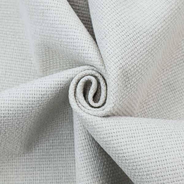A light grey or soft ash fabric featuring a distinct, tightly woven grid texture. The material showcases a multi-tonal, basket-weave style pattern with blended pale grey and subtle white threads, creating a clean, neutral, and matte finish across the entire surface.