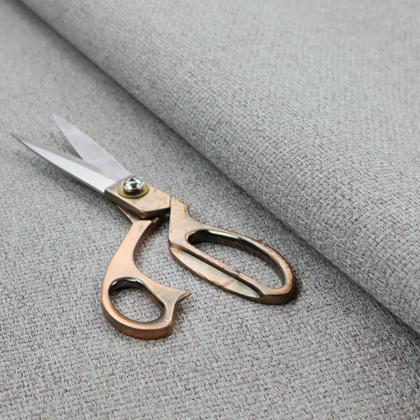 A mid-grey or stone-grey fabric featuring a distinct, tightly woven grid texture. The material showcases a multi-tonal, basket-weave style pattern with blended cool grey, taupe, and subtle white threads, creating a grounded, textured neutral, and matte finish across the entire surface.