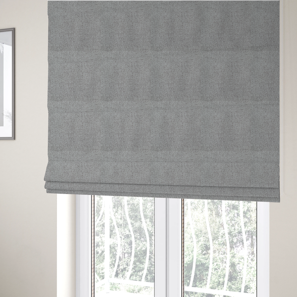 The fabric used to create these Roman blinds is a mid-grey or stone-grey fabric featuring a distinct, tightly woven grid texture. The material showcases a multi-tonal, basket-weave style pattern with blended cool grey, taupe, and subtle white threads, creating a grounded, textured neutral, and matte finish across the entire surface.