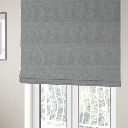 The fabric used to create these Roman blinds is a mid-grey or stone-grey fabric featuring a distinct, tightly woven grid texture. The material showcases a multi-tonal, basket-weave style pattern with blended cool grey, taupe, and subtle white threads, creating a grounded, textured neutral, and matte finish across the entire surface.