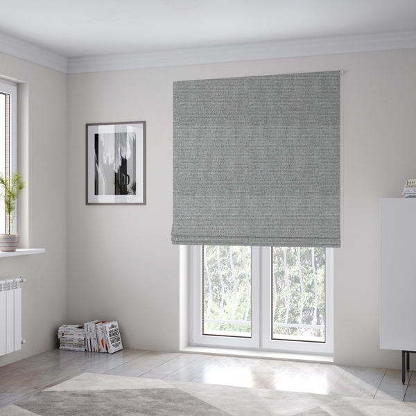 The fabric used to create these Roman blinds is a mid-grey or stone-grey fabric featuring a distinct, tightly woven grid texture. The material showcases a multi-tonal, basket-weave style pattern with blended cool grey, taupe, and subtle white threads, creating a grounded, textured neutral, and matte finish across the entire surface.