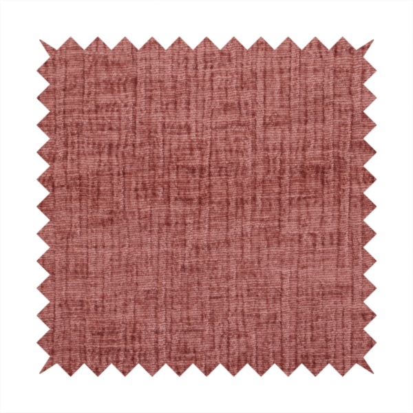 A textured upholstery fabric in a dusty rose or terracotta pink colour. The fabric features a raised, cross-hatched slub texture with subtle vertical and horizontal ridges, giving it a cosy, slightly distressed chenille appearance.