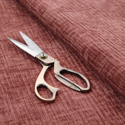 A textured upholstery fabric in a dusty rose or terracotta pink colour. The fabric features a raised, cross-hatched slub texture with subtle vertical and horizontal ridges, giving it a cosy, slightly distressed chenille appearance.