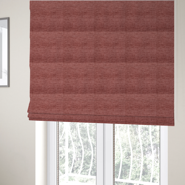 The fabric used to create these Roman blinds is a textured upholstery fabric in a dusty rose or terracotta pink colour. The fabric features a raised, cross-hatched slub texture with subtle vertical and horizontal ridges, giving it a cosy, slightly distressed chenille appearance.