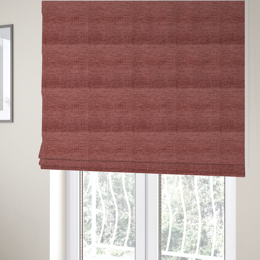 The fabric used to create these Roman blinds is a textured upholstery fabric in a dusty rose or terracotta pink colour. The fabric features a raised, cross-hatched slub texture with subtle vertical and horizontal ridges, giving it a cosy, slightly distressed chenille appearance.