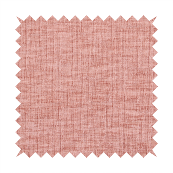 A textured upholstery fabric in a soft, light blush pink shade. The material features a distinctive cross-hatched slub texture with fine vertical and horizontal ridges, creating a plush, tactile chenille finish.