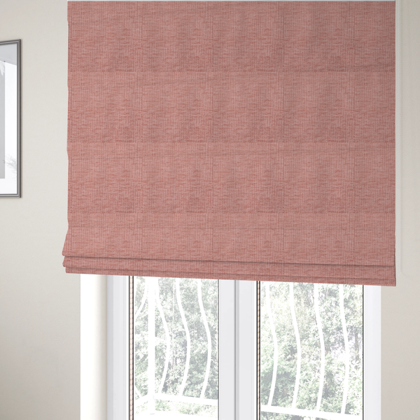 The fabric used to create these Roman blinds is a textured upholstery fabric in a soft, light blush pink shade. The material features a distinctive cross-hatched slub texture with fine vertical and horizontal ridges, creating a plush, tactile chenille finish.