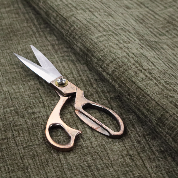 A textured upholstery fabric in an earthy olive or sage green colour. The material features a prominent cross-hatched slub texture with subtle horizontal and vertical ridges, giving it a cosy, multi-dimensional chenille appearance.
