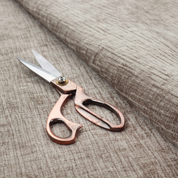 A textured upholstery fabric in a neutral taupe or greige colour. The material features a distinctive cross-hatched slub texture with subtle vertical and horizontal ridges, creating a soft, dimensional chenille finish.